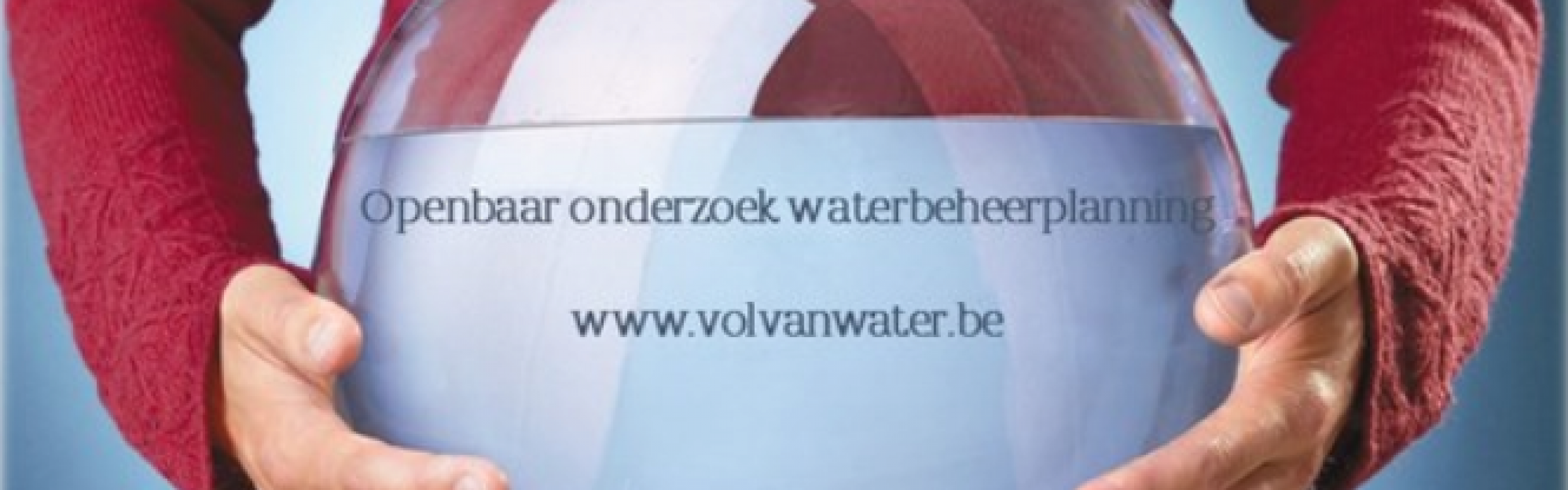 Iemand houdt een bokaal vast met daarin een blad van de waterbeheerplanning.