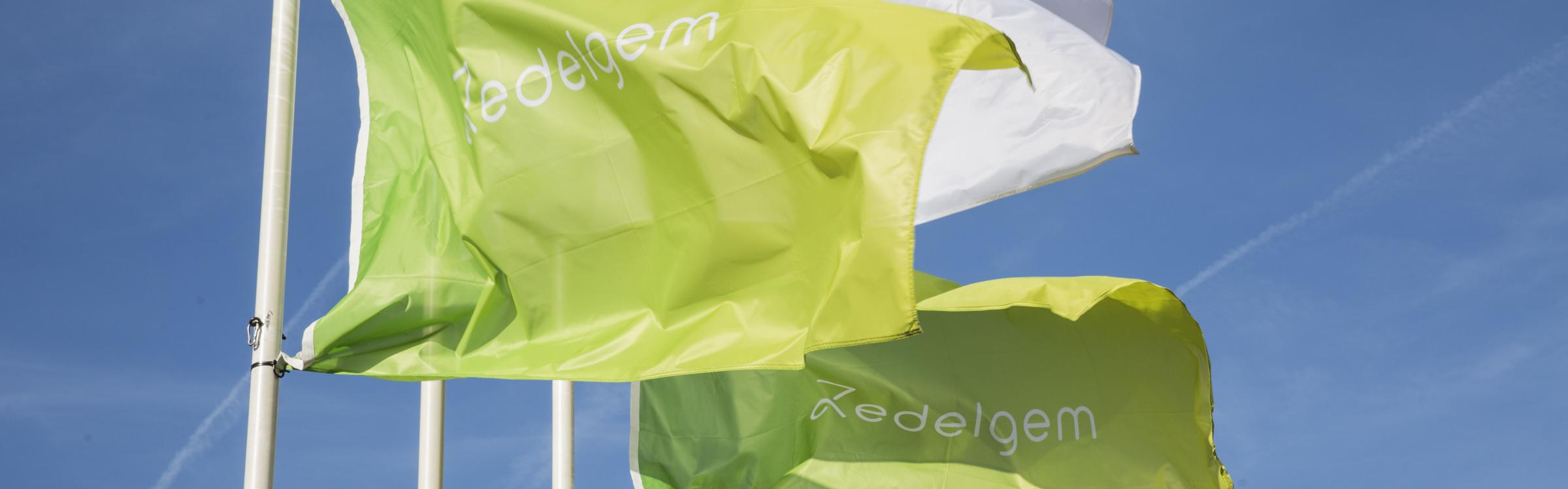 Vlaggen wapperen voor het gemeentehuis van Zedelgem.