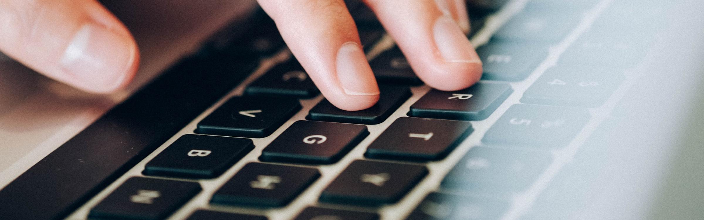 Iemand is aan het typen op het toetsenbord op het nieuw online loket.