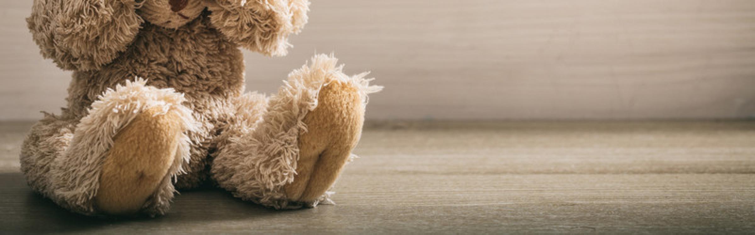 Een knuffelbeertje doet zijn handen voor zijn ogen in teken van intrafamiliaal geweld