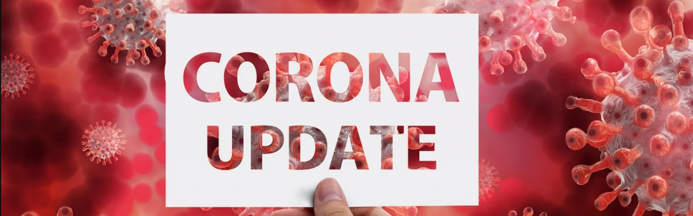 Een persoon houdt een kaart vast met daarop 'corona update'.