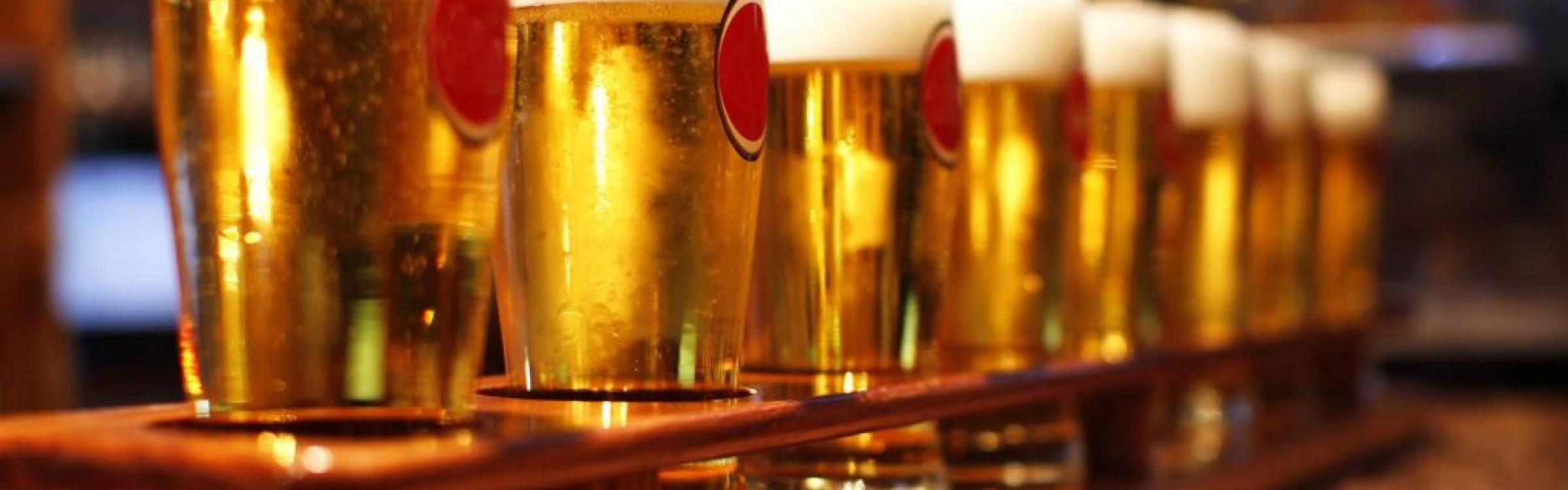 Glazen bier staan klaar op de toog.