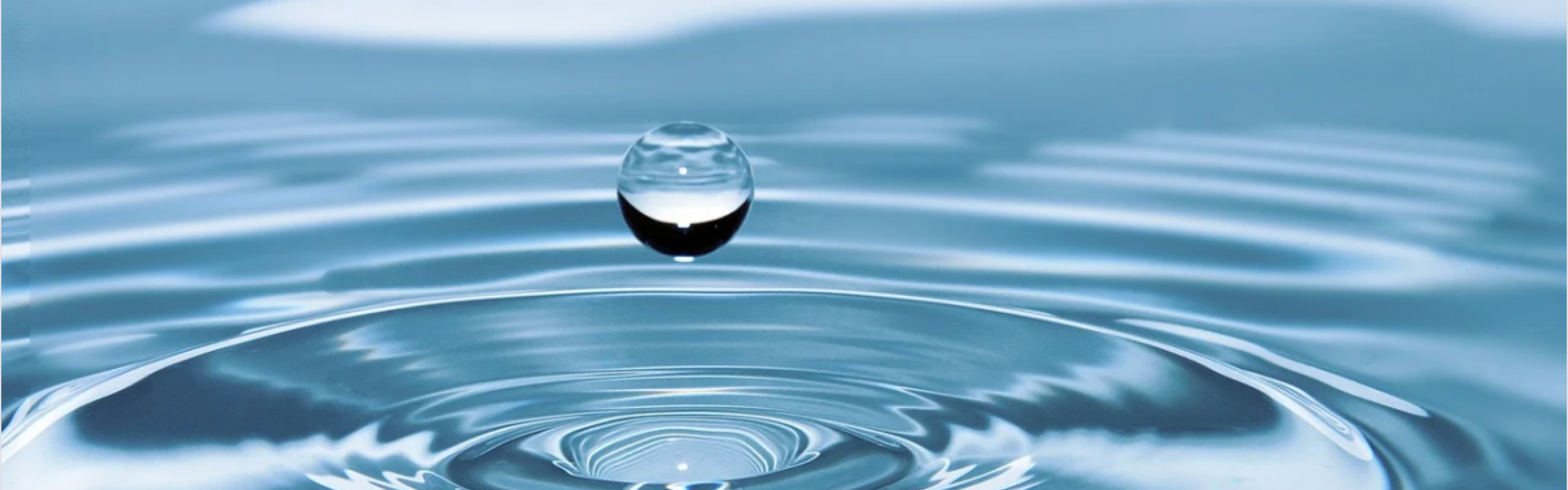 Een druppel water valt in een grote plas.