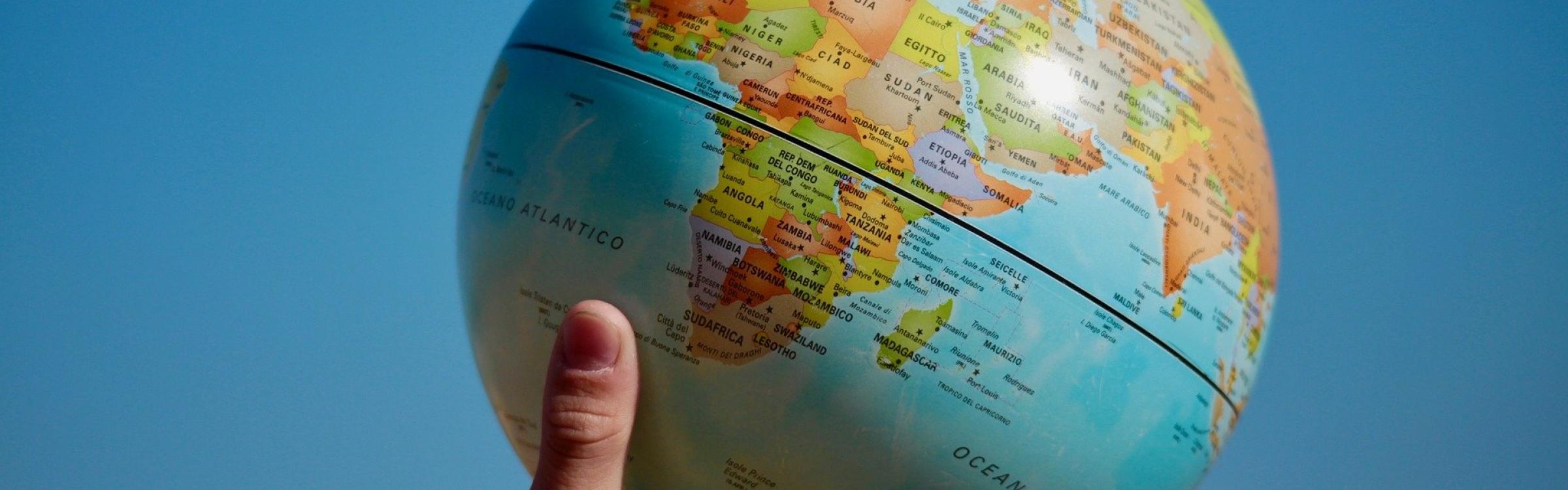 Een persoon houdt de wereldbol in de lucht.