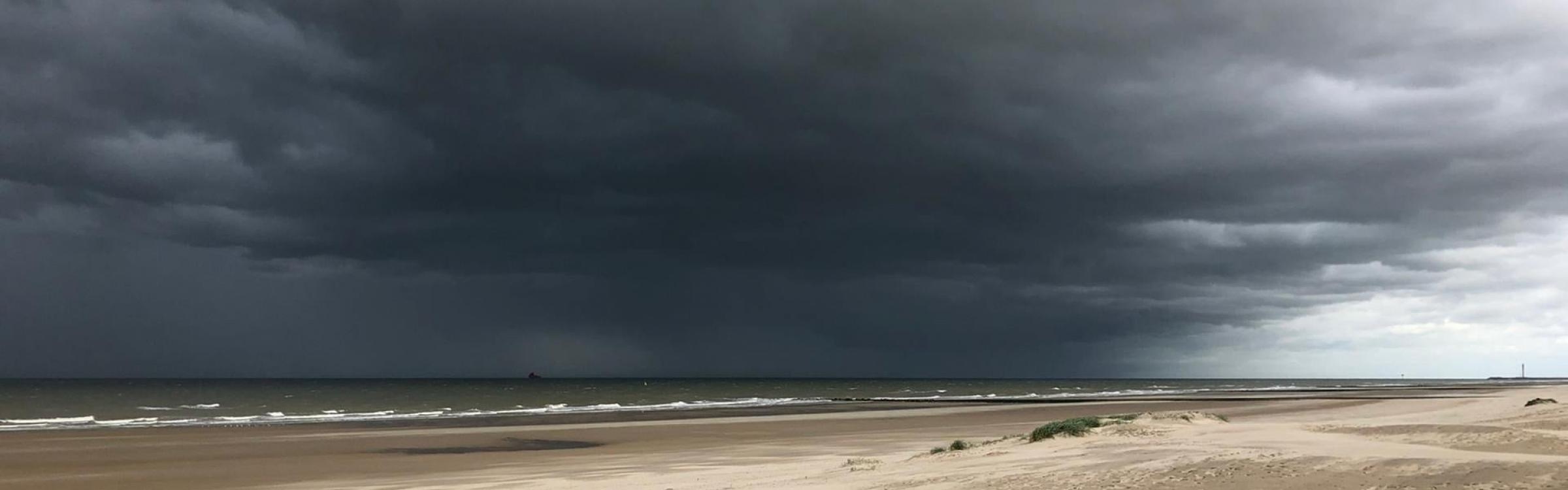 Een storm raast over de zee en zorgt voor hoge golven.