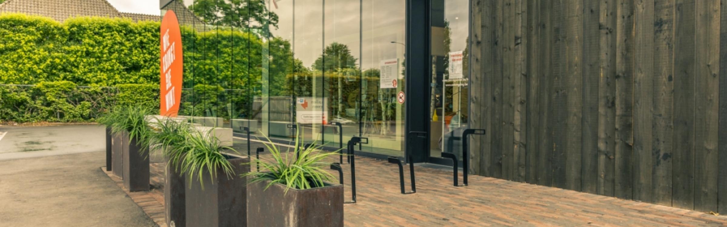 De kringloopwinkel met plantjes ervoor.