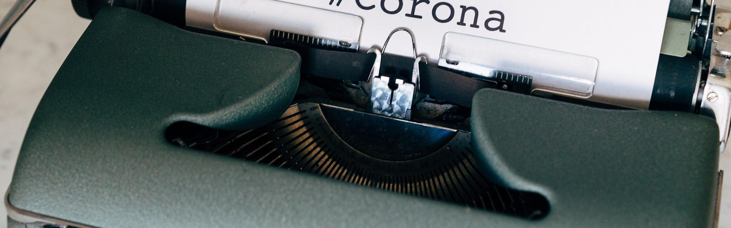 Een blad papier met het woord corona op komt uit de typemachine.