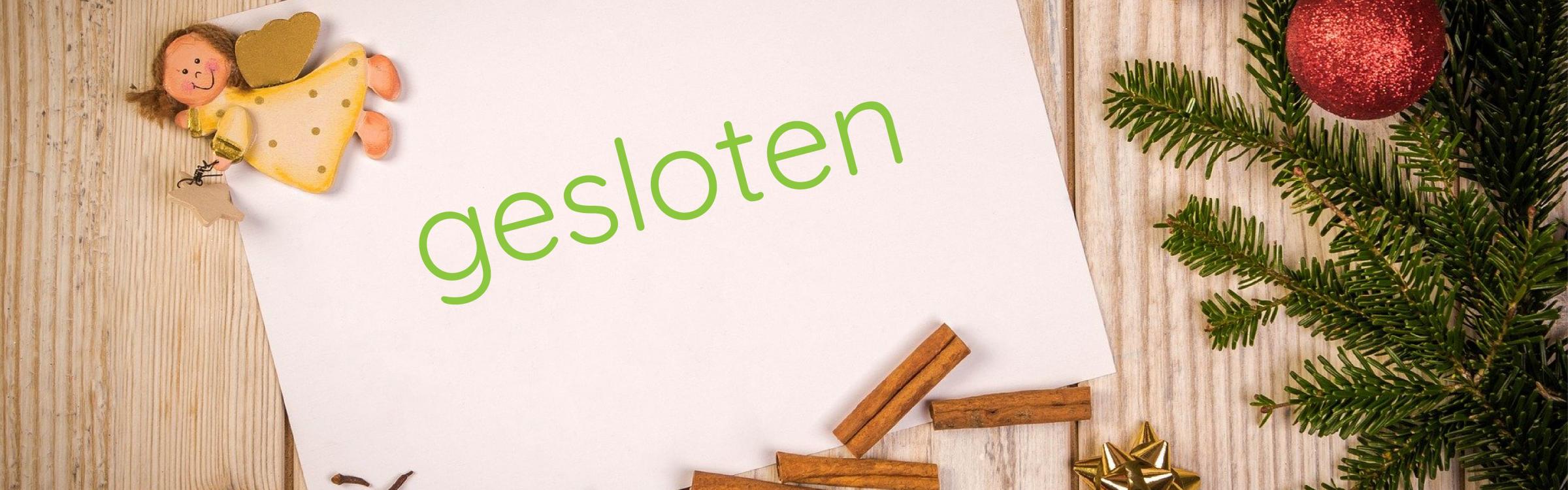 Een blad papier met het woord gesloten op, met rondom kerstversiering.