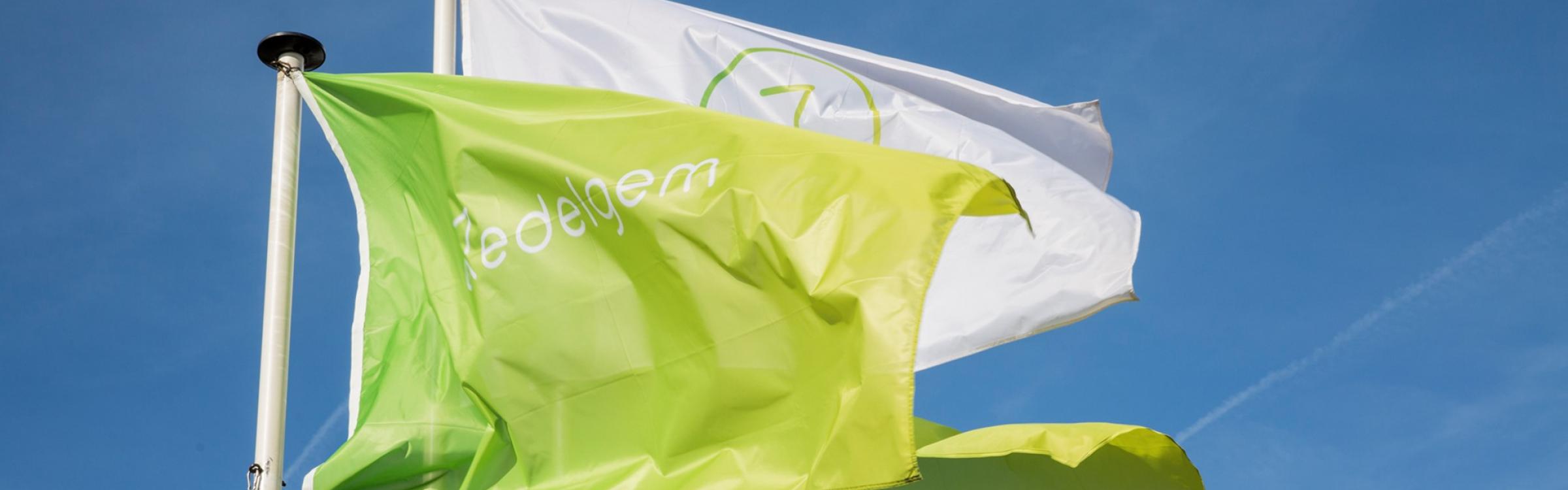 Vlaggen wapperen voor het gemeentehuis van Zedelgem.