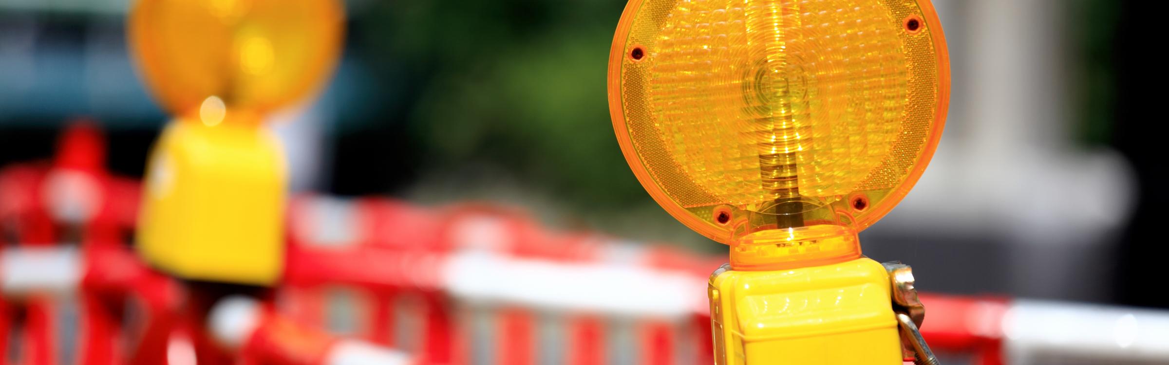 Signalisatie hekkens en lichten kondigen de werken op de weg aan.