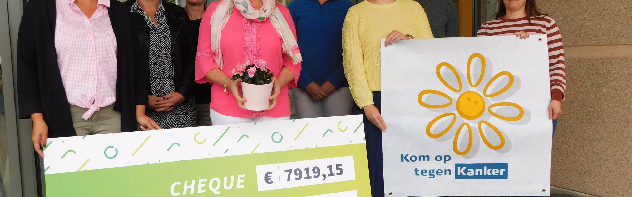 Het lokaal bestuur schenkt de cheque aan het goede doel Kom op Tegen Kanker.