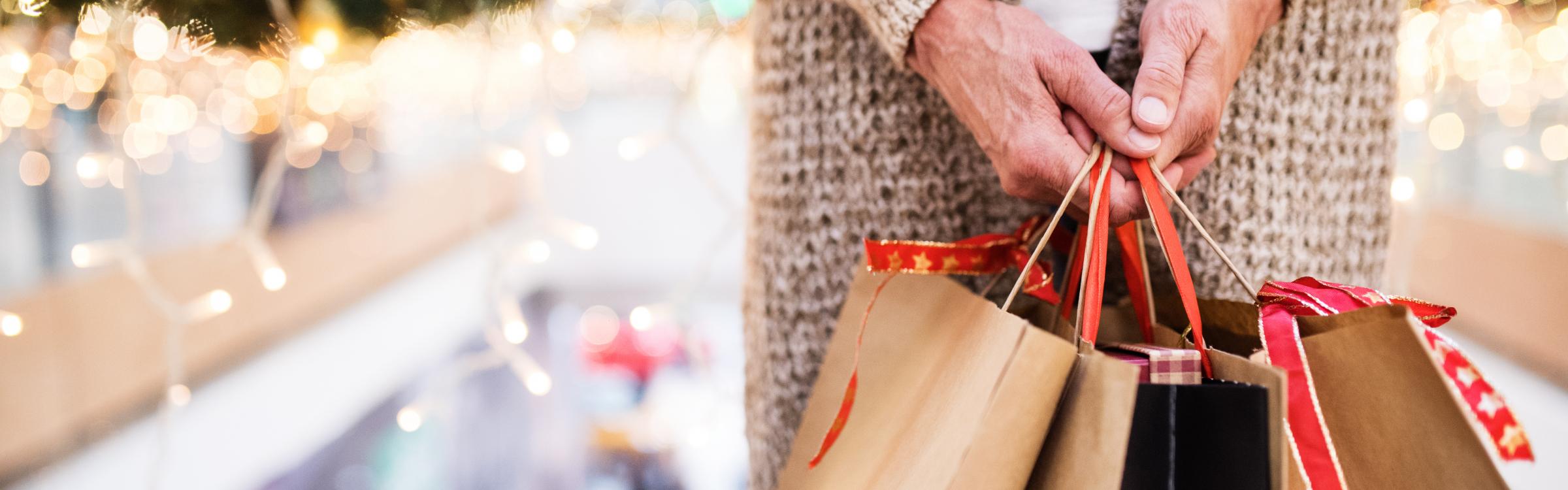 Iemand is gaan shoppen en heeft verschillende zakken in haar handen.