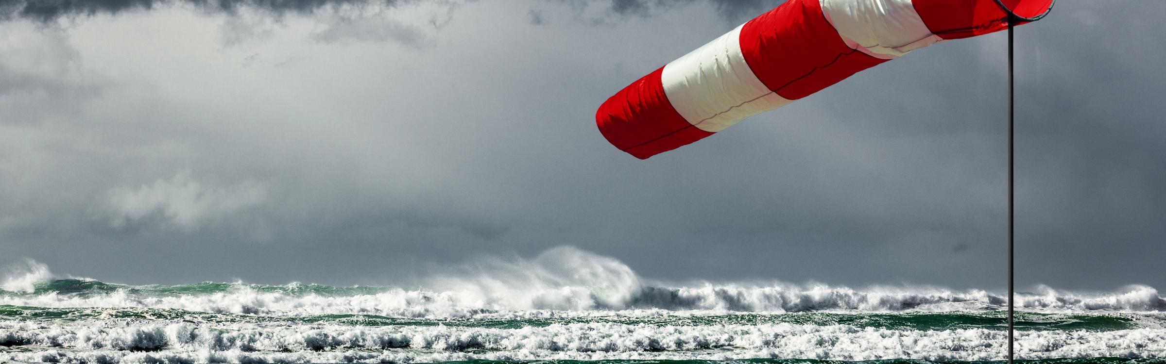 Een storm raast over de zee en zorgt voor hoge golven.