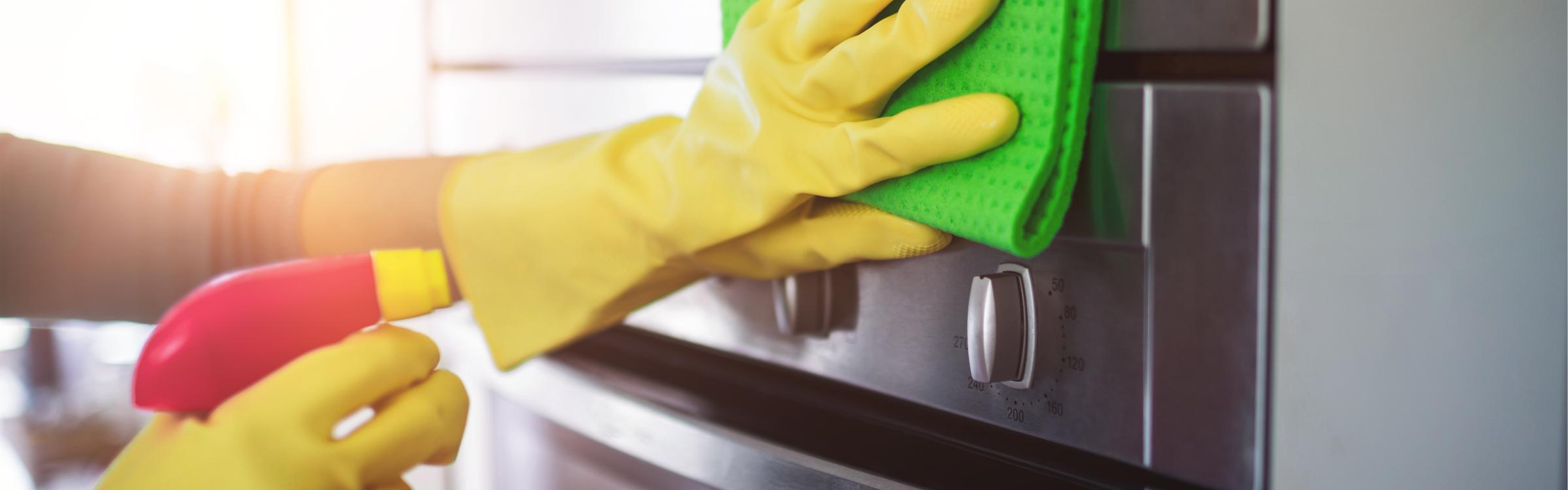 Iemand kuist de oven af met een natte vot.