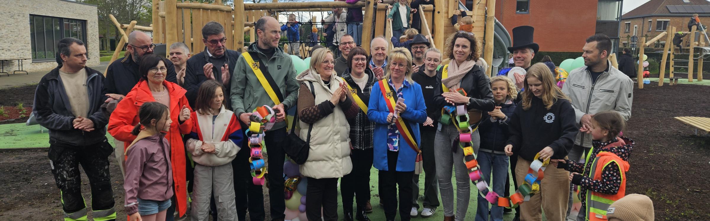 Groepsfoto gemeentebestuur en kinderen op het nieuwe speelplein in Loppem.