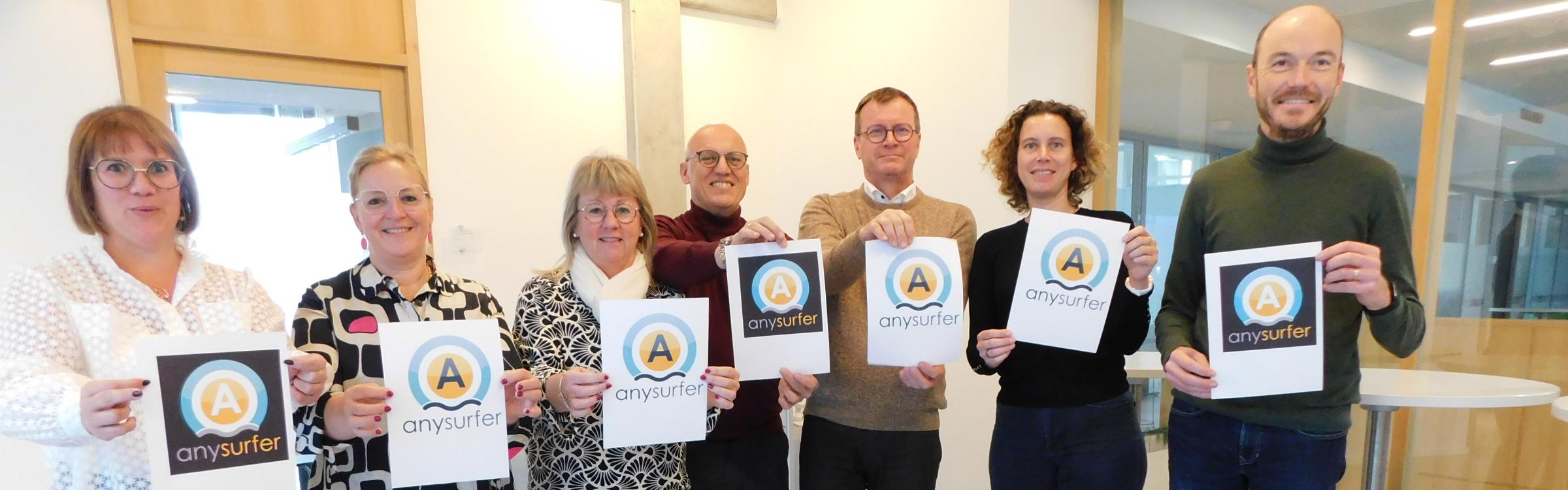 Het college van burgemeester en schepenen met het logo van Anysurfer in de hand.