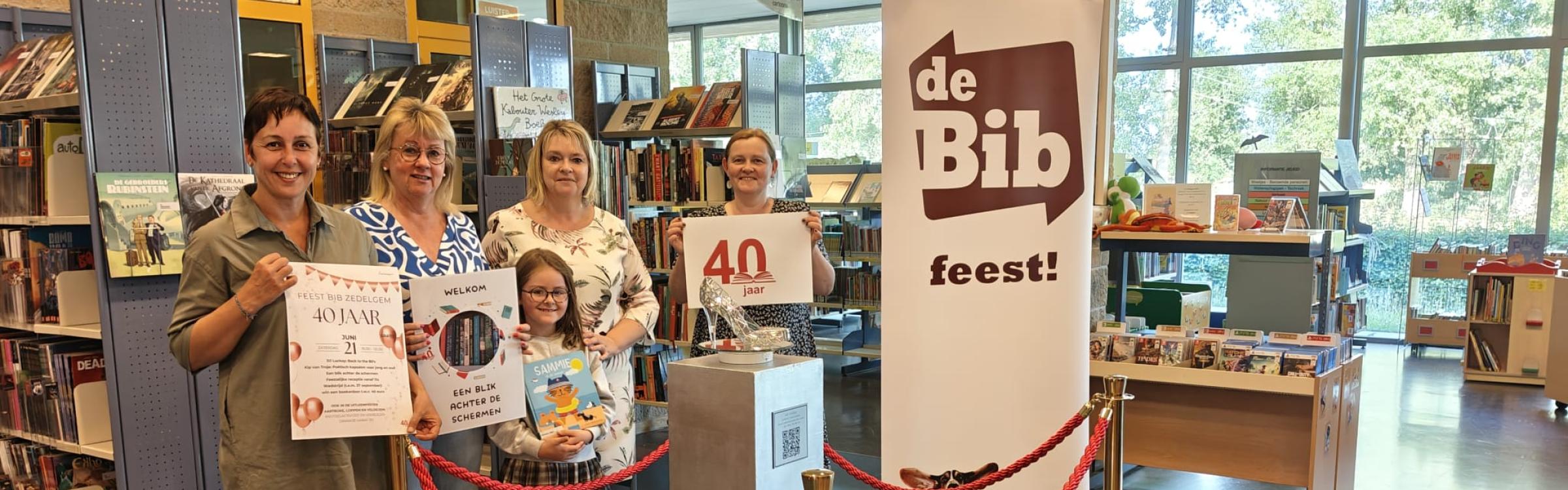 FOTO van links naar rechts: Schepen van bibliotheek Sofie Pollet, burgemeester Annick Vermeulen en medewerkers van de bib Nancy Missine en Maartje Clarie. (Bij het glazen schoentje momenteel in het kader van een sprookjestentoonstelling in de bib)