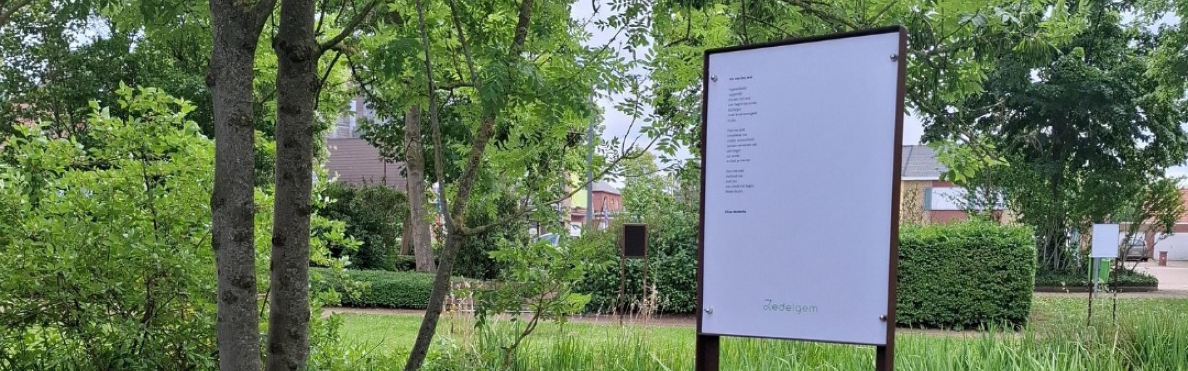 afbeelding van een gedicht in een metalen frame aan de vijver in het park van het gemeentehuis