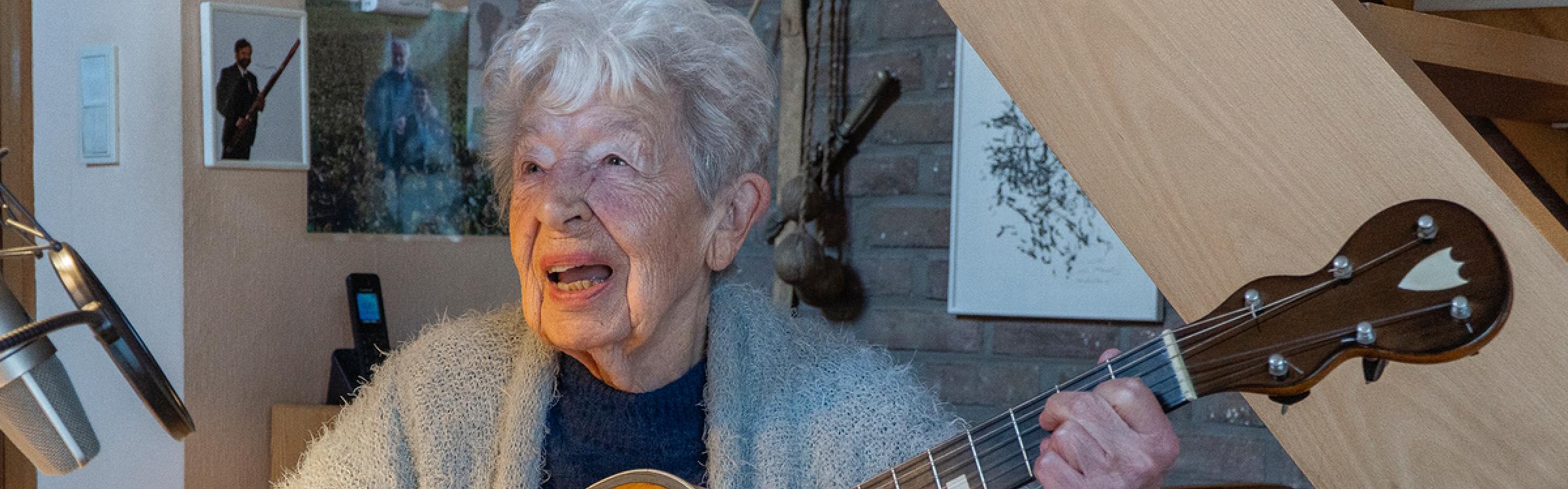 Alice Toen zingt en speelt op een akoestische gitaar