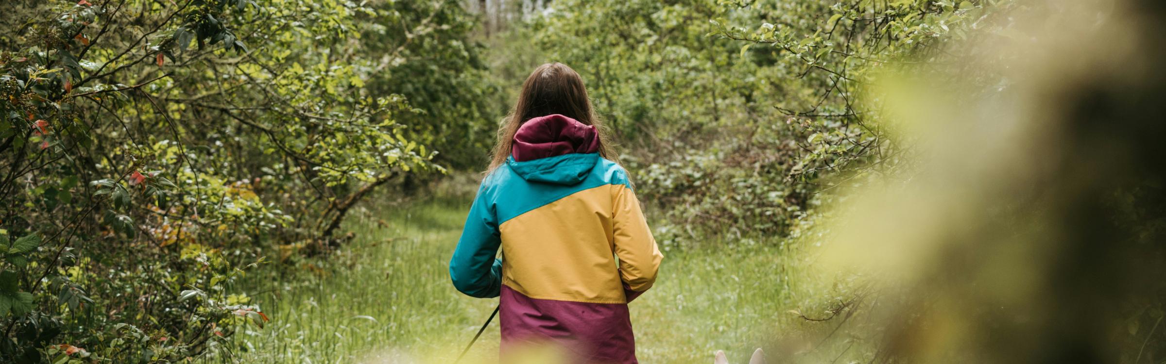 Jonge vrouw op wandel in de natuur met haar 2 honden