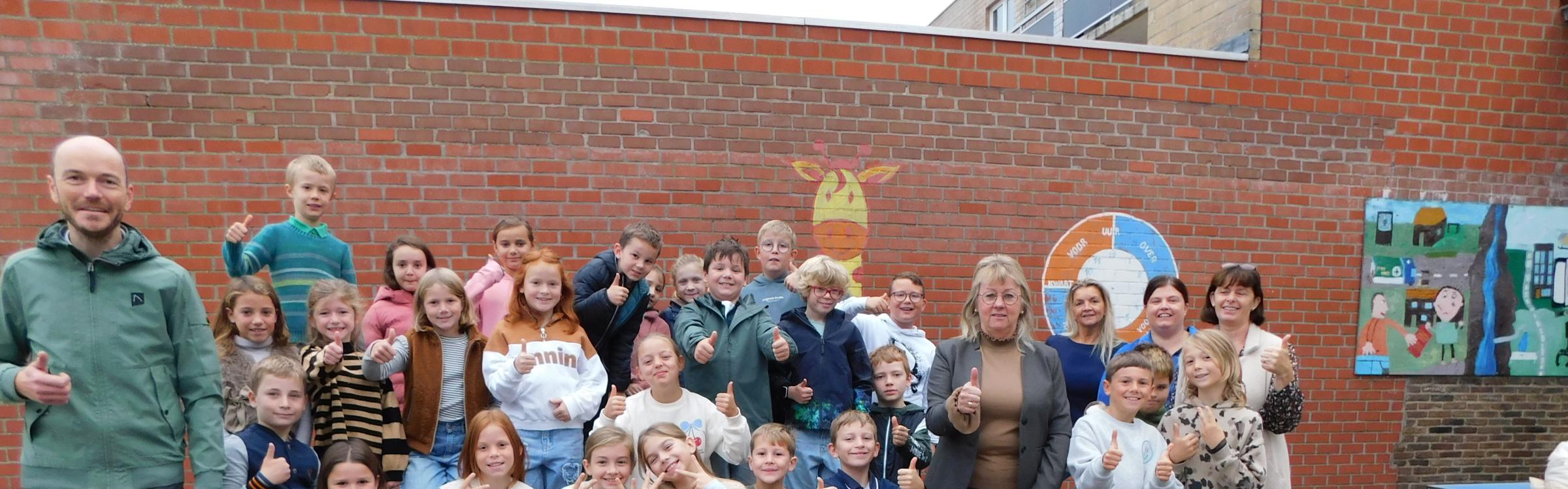 Leerlingen in groep met het gemeentebestuur met de cheque van operatie proper