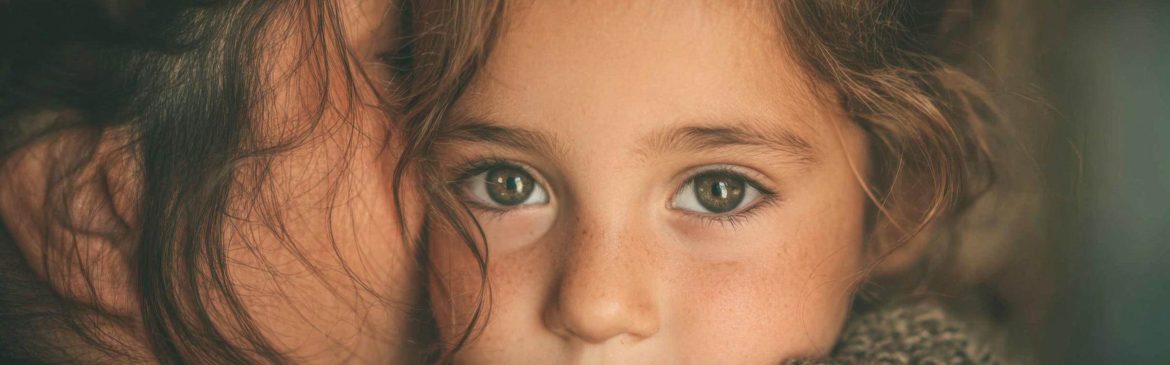 Kind en (pleeg)ouder geven elkaar een knuffel