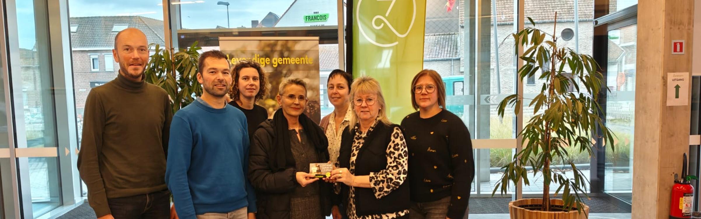 Groepsfoto van college burgemeester en schepenen met winnares van de actie 'lokaal, da's logisch'