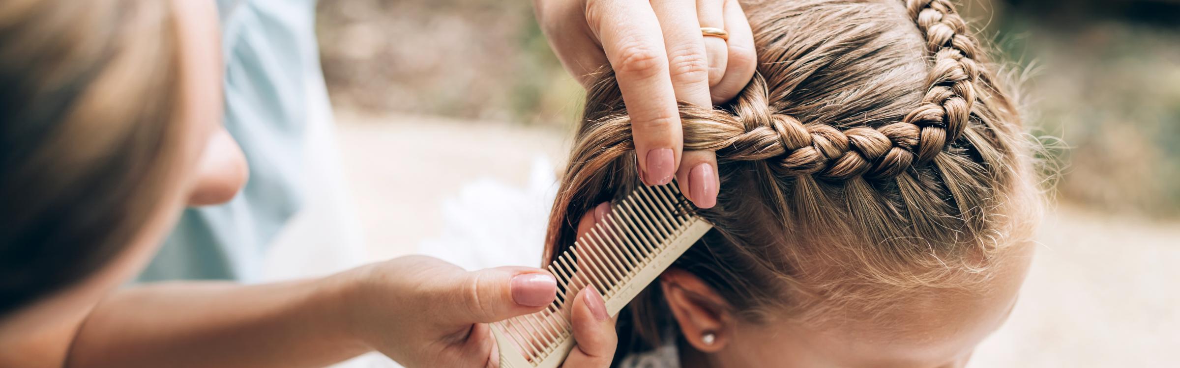 Vrouw vlecht het haar in van een jong meisje