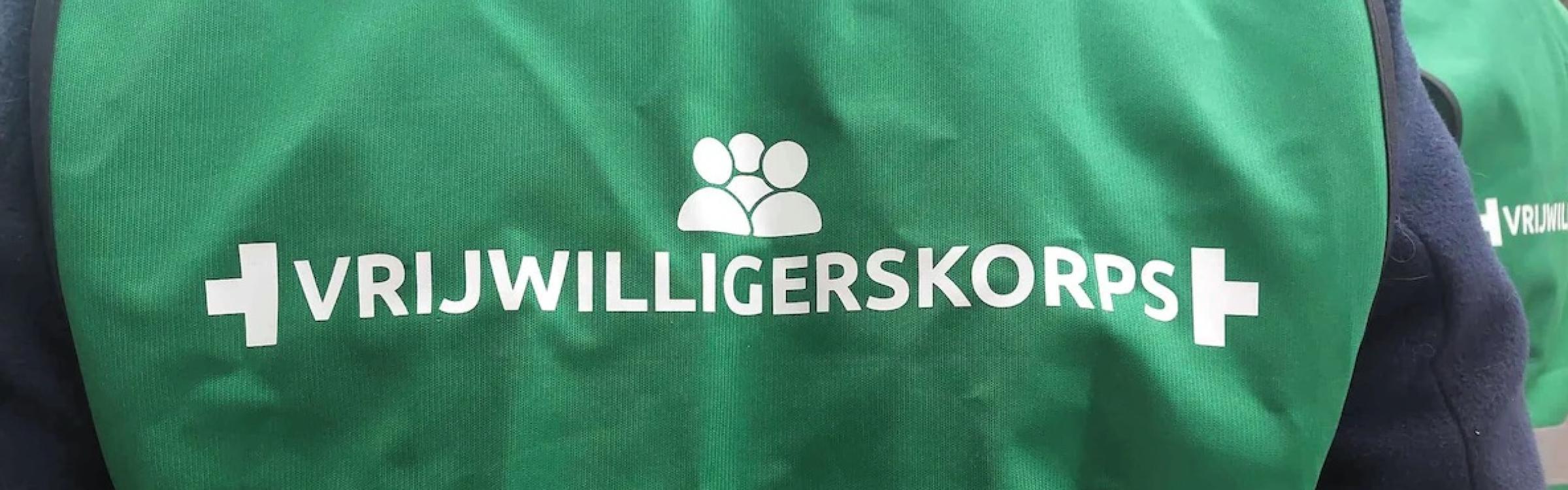 persoon met groen hesje aan van het vrijwilligerskorps