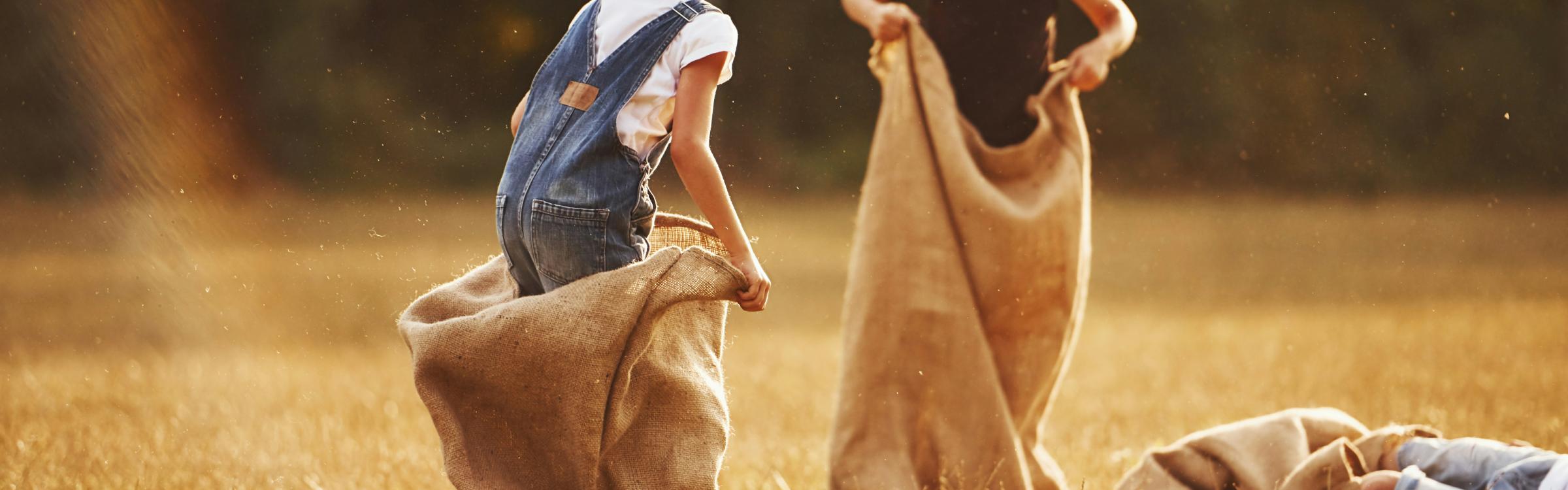 Kindjes spelen in jute zakken