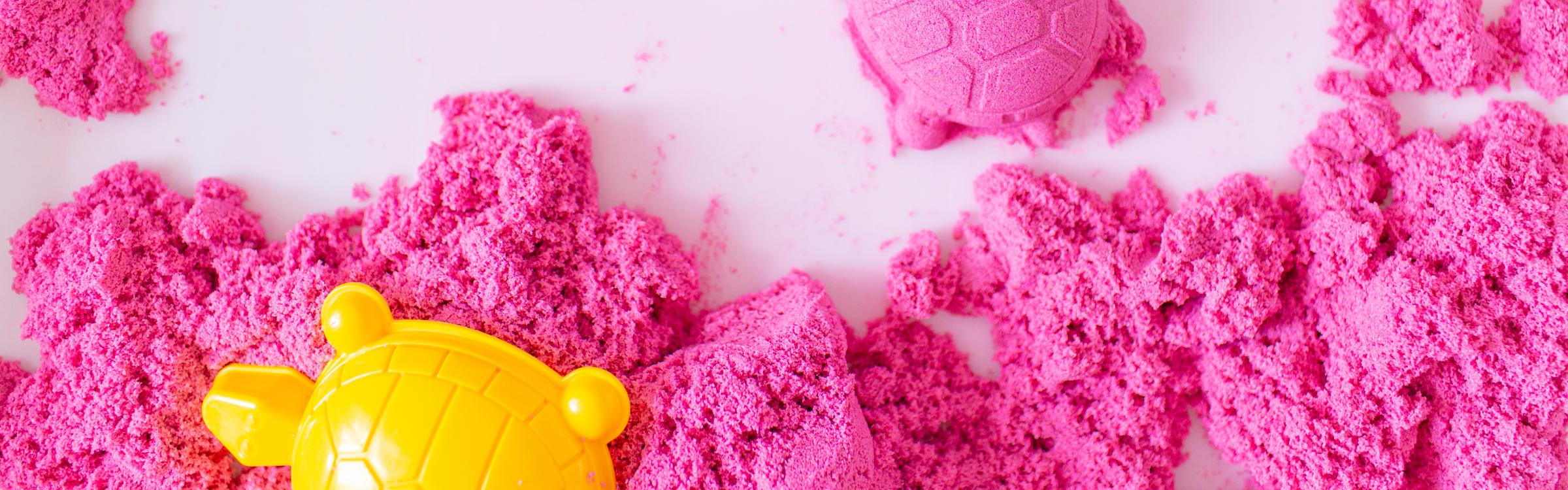 Roze kinetisch zand met speelvormpjes in