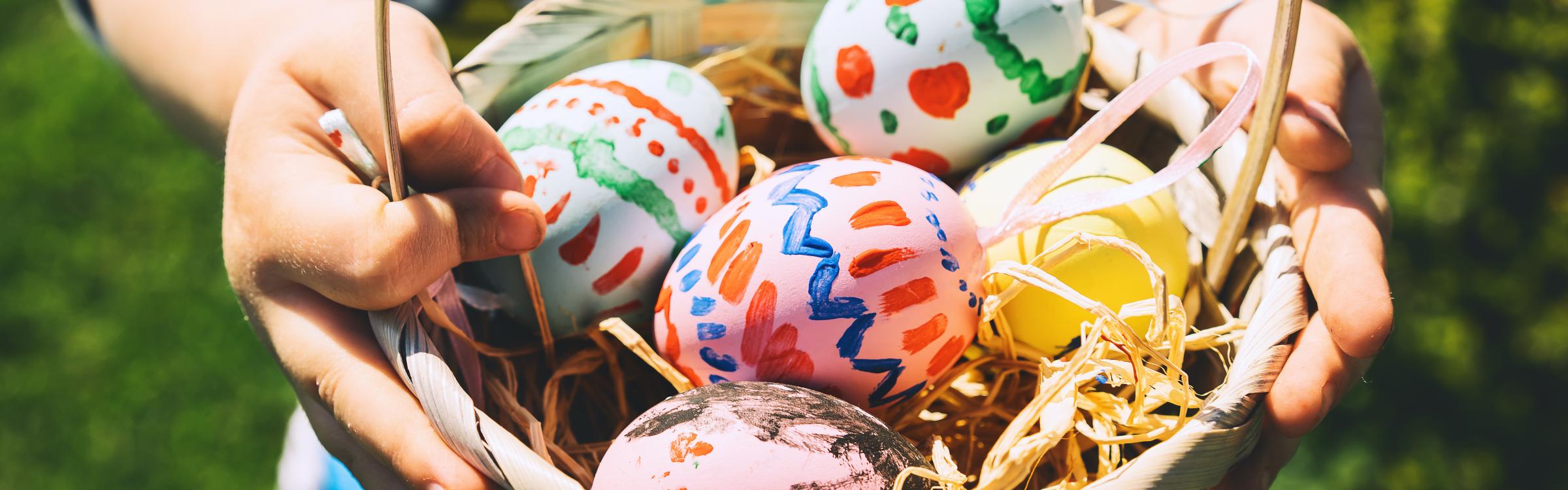 Kindje houdt een mandje vast met gekleurde paaseitjes in