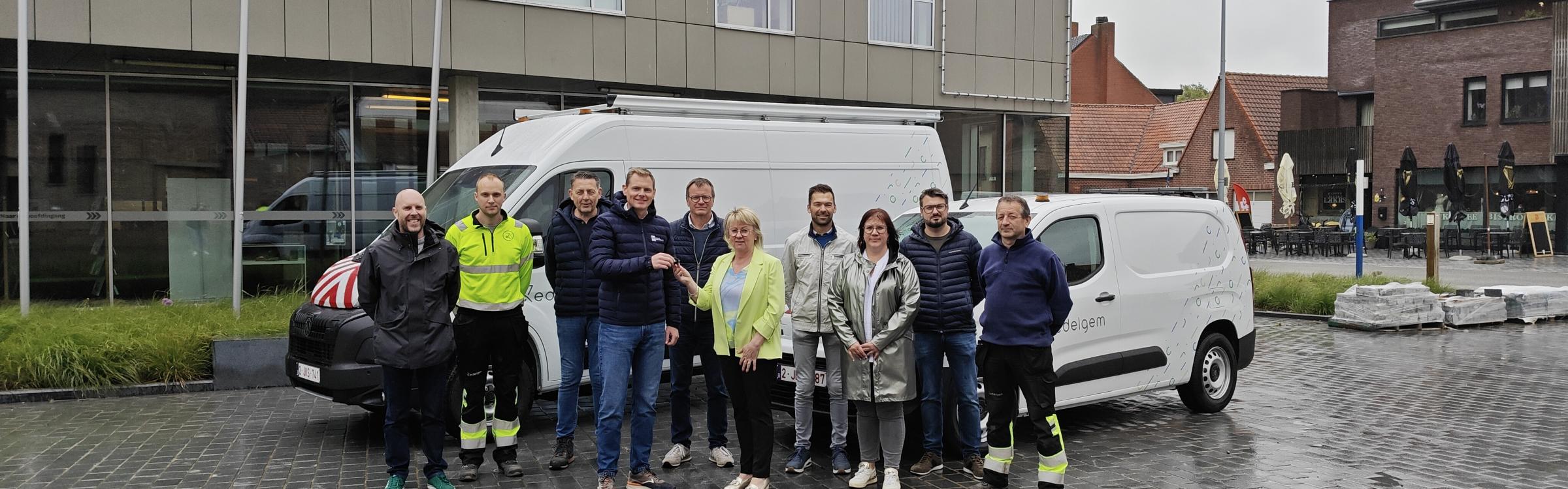 Groepsfoto van schepenen, burgemeester, medewerkers van de technische dienst en dienst gebouwen en zaakvoerders Peugeot garage aan de nieuwe auto's