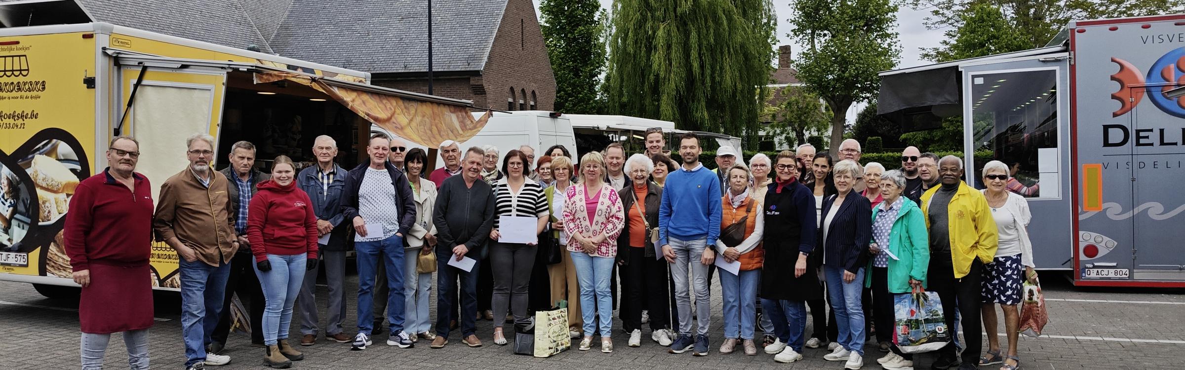 groepsfoto van de winnaars Maand van de Markt samen met burgemeester Annick Vermeulen, schepen Bart Vergote en enkele marktkramers