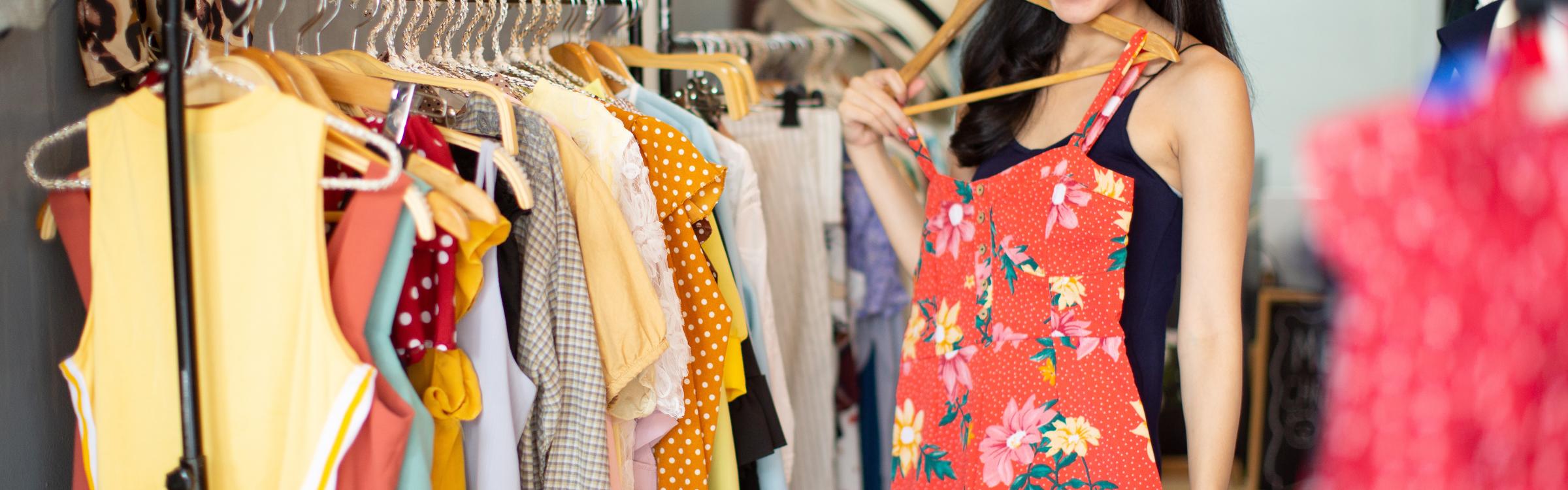 Vrouw past kledij in een winkel