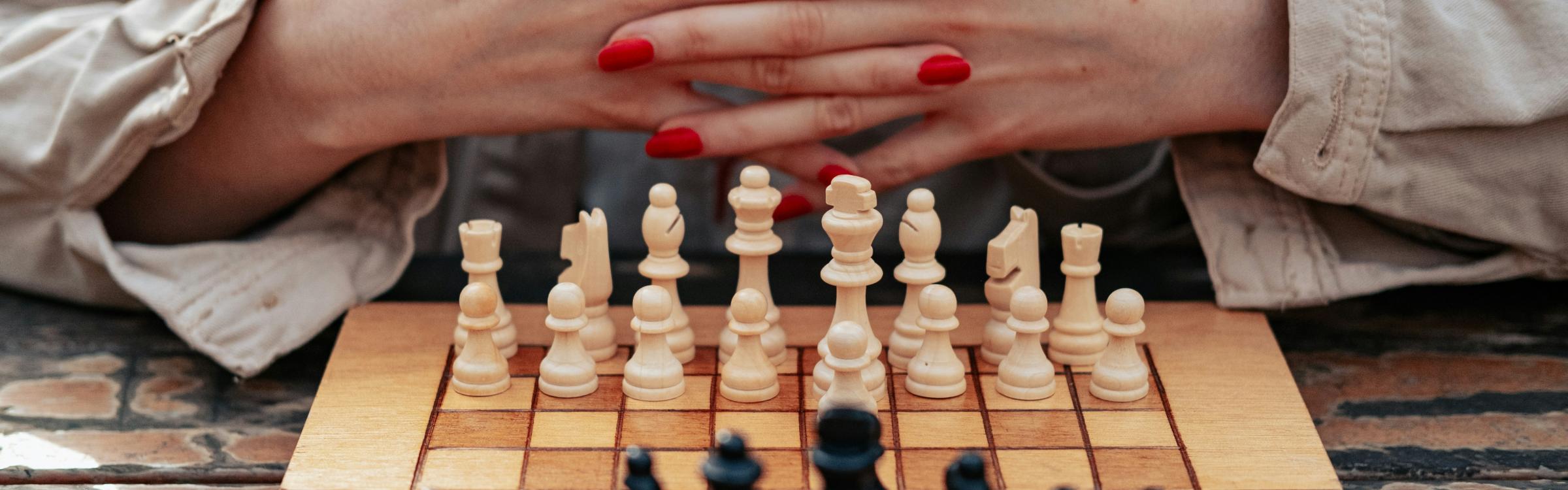 Vrouw zit klaar om een partijtje schaak te starten
