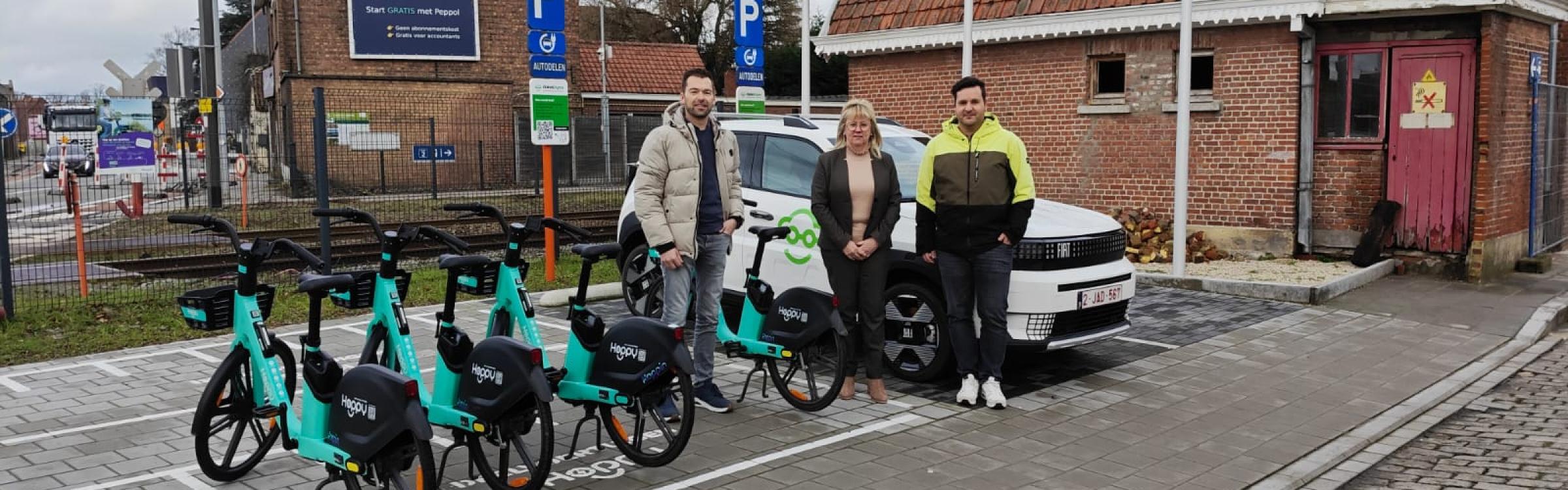 Schepen Bart Vergote, Burgemeester en deskundige mobiliteit Bart Degroote bij de deelwagens en deelfietsen aan het station van Zedelgem